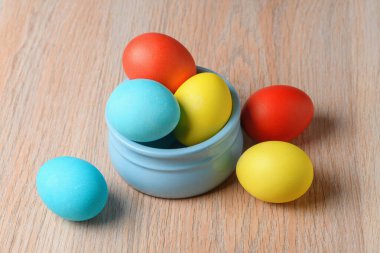 Mavi bir kasede renkli Paskalya yumurtaları. Paskalya yumurtaları, Paskalya yumurtalarının bir sembolü ve zorunlu bir özelliğidir..