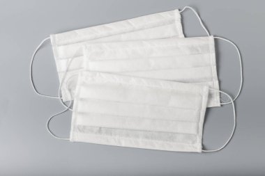 Gri arka planda beyaz tıbbi maskeler. Grip virüsünden korunmak için tıbbi maske.