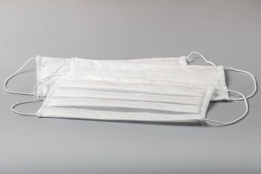 Gri arka planda beyaz tıbbi maskeler. Grip virüsünden korunmak için tıbbi maske.