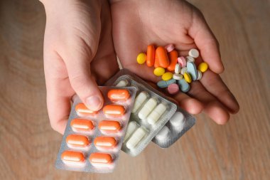 Birkaç renkli tablet el ele tutuşmuş. Hastalık durumunda yardım kavramı. Viral enfeksiyona yardım.