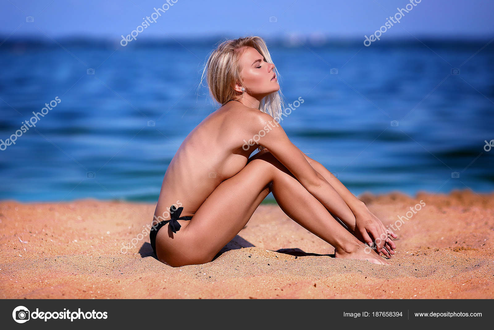 Flawless topless blond butt on the beach