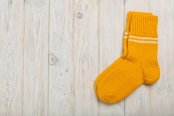 Grüne stricken Wolle Socken an hölzernen Hintergrundlicht Grüne stricken Wolle Socken an hölzernen Hintergrundlicht