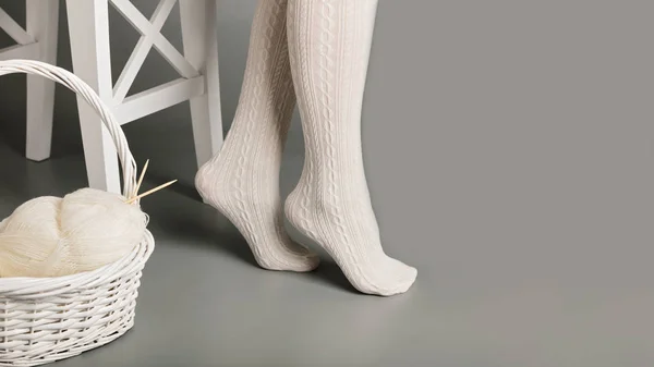 Beyaz kadın ayakları örme iplik sepetle yakınındaki tayt bir