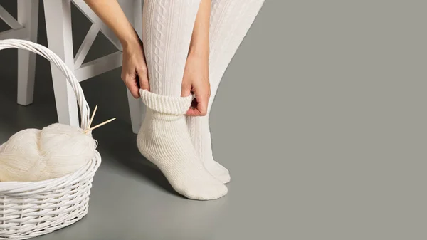 Sepet beyaz örme çorap ve çorap kadın ayakları yakınındaki
