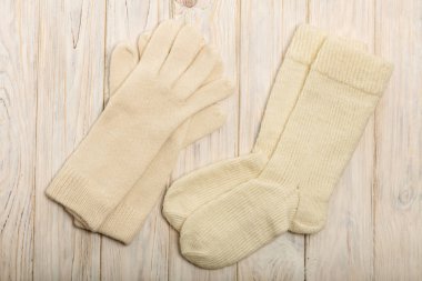 Bir beyazdan örme iplik eldiven ve çorap hafif ahşap bac üzerinde