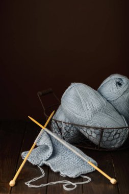 Koyu kahverengi ahşap arka plan üzerine açık mavi iplik örgü.