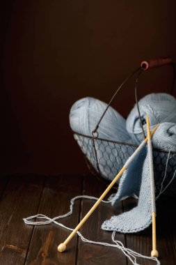 Koyu kahverengi ahşap arka plan üzerine açık mavi iplik örgü.