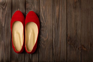 Ahşap arka plan üzerinde kırmızı kadın ayakkabı (balerinler). 