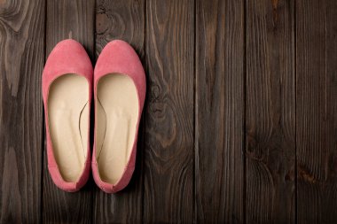 Kadın Ayakkabı (balerinler) ahşap arka plan üzerinde pembe.
