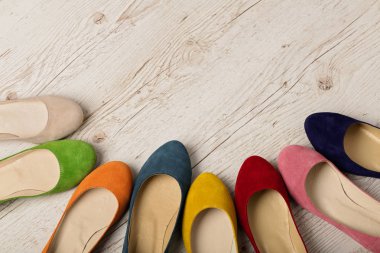 Beyaz ahşap arka plan üzerinde renkli ayakkabı (balerinler) satır.