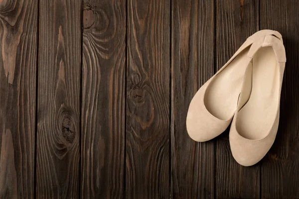 Beige women\'s shoes (ballerinas) on wooden background.