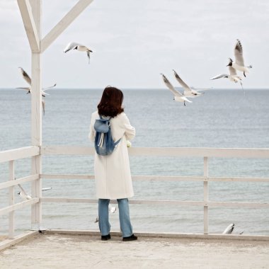 Genç kadın (esmer) Beyaz önlük martılar beslemeleri olmak