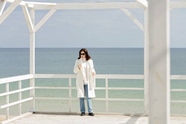 Promenade beyaz paltolu genç kadın (esmer)