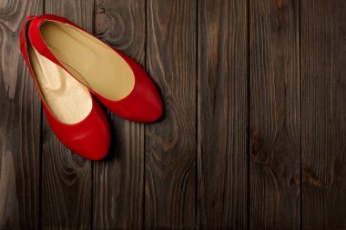 Ahşap arka plan üzerinde kırmızı kadın ayakkabı (balerinler). 
