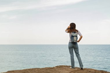 Kot pantolon, çizgili üst ve spor ayakkabı beach b genç kadın
