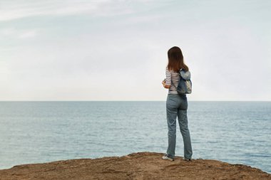 Kot pantolon, çizgili üst ve spor ayakkabı beach b genç kadın