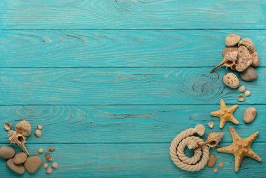 İp, taşları, deniz kabukları ve deniz yıldızı ile bir turkuaz sınır