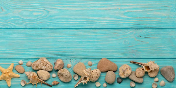 İp, taşları, deniz kabukları ve deniz yıldızı ile bir turkuaz sınır