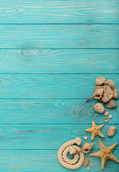 İp, taşları, deniz kabukları ve deniz yıldızı ile bir turkuaz sınır