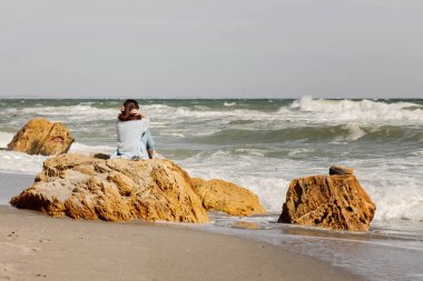 Genç kadın (esmer) bir ışık altında mavi hırka ve kot pantolon, ile 