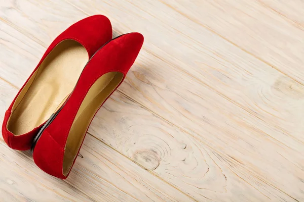Ahşap arka plan üzerinde kırmızı kadın ayakkabı (balerinler).