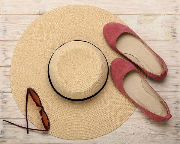 Women's shoes, hat and sunglasses of pink color.