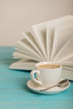 Kitap ve ahşap mavi arka plan üzerinde kahve. 