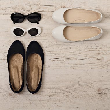 Beyaz ve siyah kadın ayakkabı ve güneş gözlüğü. 