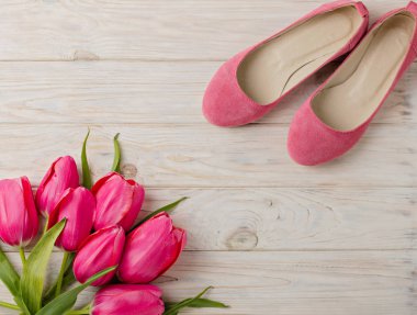 Kadın Ayakkabı ve ahşap arka plan üzerinde Pembe Lale buketi.