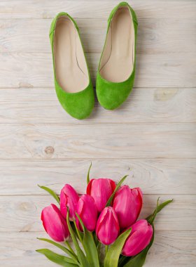 Kadın Ayakkabı ve ahşap arka plan üzerinde Pembe Lale buketi.