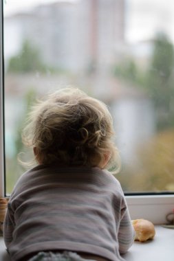 bebek pencereden dışarı bakıyor.