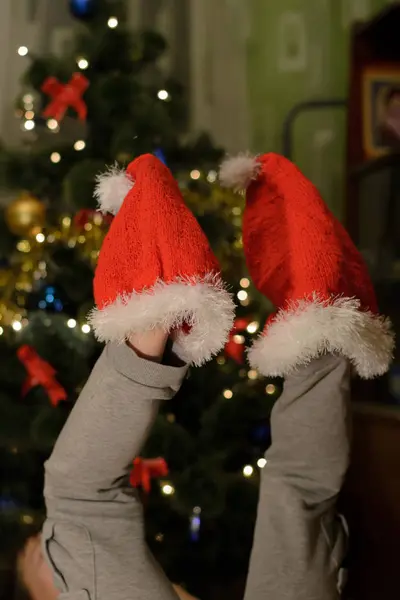 Two Santa Claus hat on the legs of the child — Stock Photo, Image