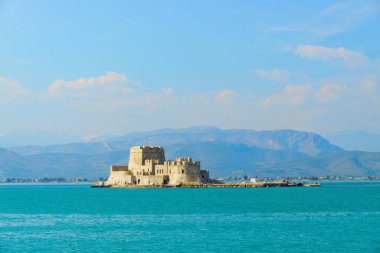 Yunanistan 'ın Nafplio şehrinin güzel limanı. Geleneksel teknesi ve mavi sularda Bourtzi kalesi. Popüler yaz seyahatleri