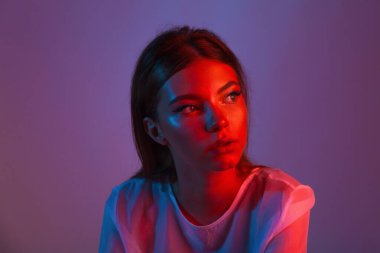 Neon yakın plan genç kadın portresi. Stüdyo çekimi. Mor, kırmızı ve pembe ışıklarla poz veren bir model. Moda 80 'lere geri döndü - 90' ların yeni moda konsepti.