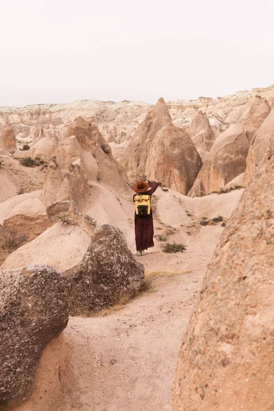 Egy Utazó Barna Kalapban Hosszú Ruhában Sárga Hátizsákkal Sivatagi Völgyben — Stock Fotó