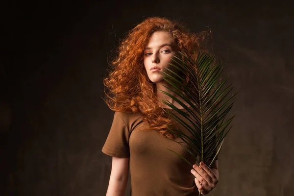 Enerjik genç, kıvırcık, kızıl saçlı kadın.