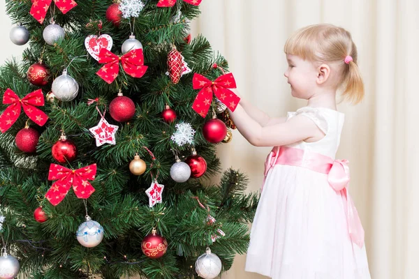 Kind versieren van de kerstboom Rechtenvrije Stockafbeeldingen