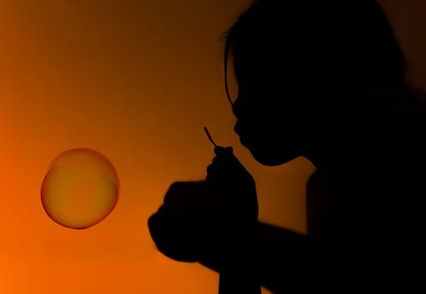 Silueta. dívka si hraje s mýdlové bubliny — Stock fotografie