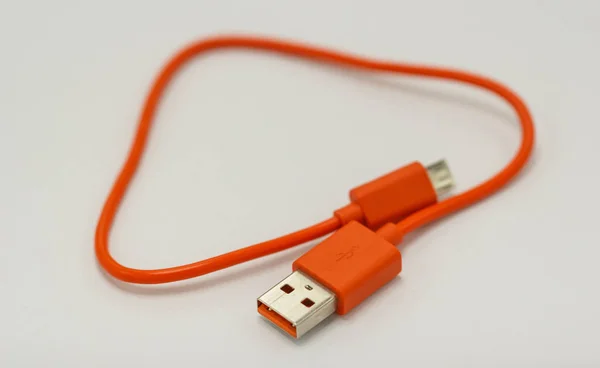 Cabos USB laranja. para conexão diferentes dispositivos de tecnologia — Fotografia de Stock