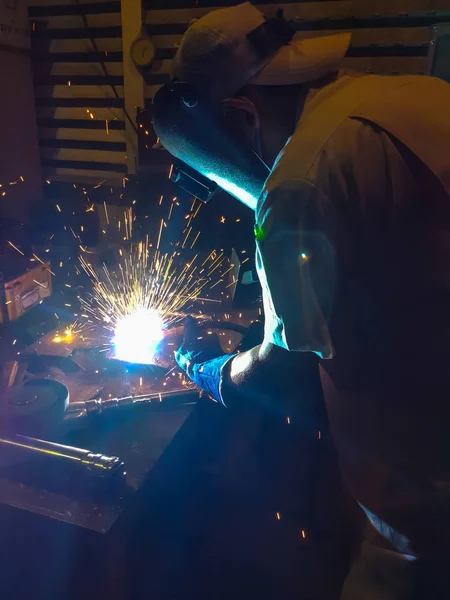 Worker, welding steel in factory manufacturing industry