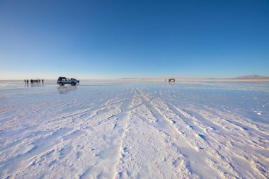 Gün batımında Bolivya Uyuni çölünde turistler