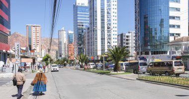 La Paz Bolivya 26 Ağustos, Calacoto bölgesindeki modern gökdelenler arasında geleneksel kıyafetler giyen bir çift yürüyor. Çekim 26 Ağustos 2019