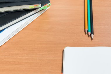 Açık defter ile üç kalem