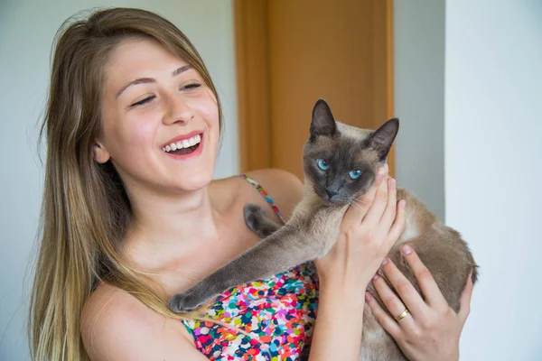 Kedisiyle mutlu genç bir kadın