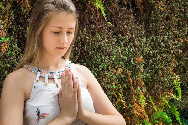 Mujer joven namaste pose en pared viva — Foto de Stock