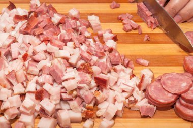 İtalyan sucuk ve pastırma ahşap tahta üzerinde küçük parçalar halinde kesilmiş.