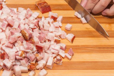 Çelik bıçak ile bir kişi tarafından bir kesme tahtası et kesmek pastırma