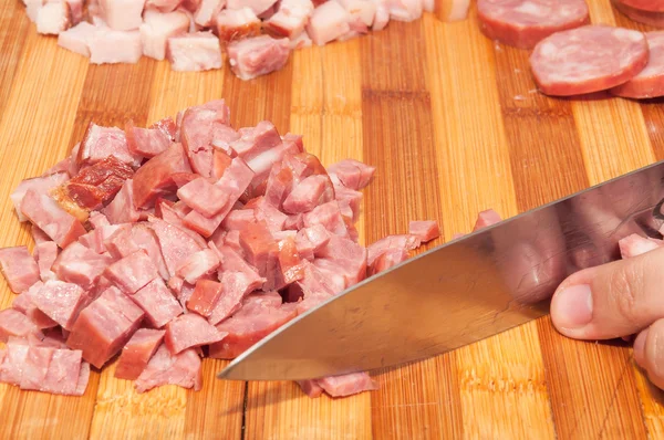 Italian sausage cut into small pieces on wooden board. — Stock Photo, Image