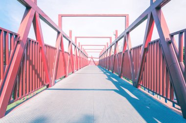 Metal yapı ile kırmızı köprü. Perspektif, uzun yaya geçidi satırlarında.
