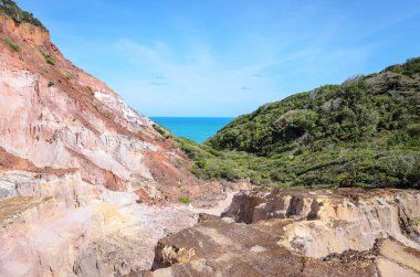 Kanyon birçok taşlarla zaman, posalı ve kayalıklarla kayalar kırmızı ve sarı renkler ve denizin içinde belgili tanımlık geçmiş.